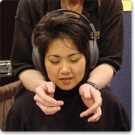 Attendee listening to a relaxation audio while receiving her chair massage