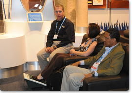 Booth staff talking to visitors while they wait for their chair massage